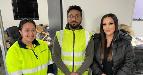 Graduate Aslam Mohammed standing between two colleagues in Melbourne